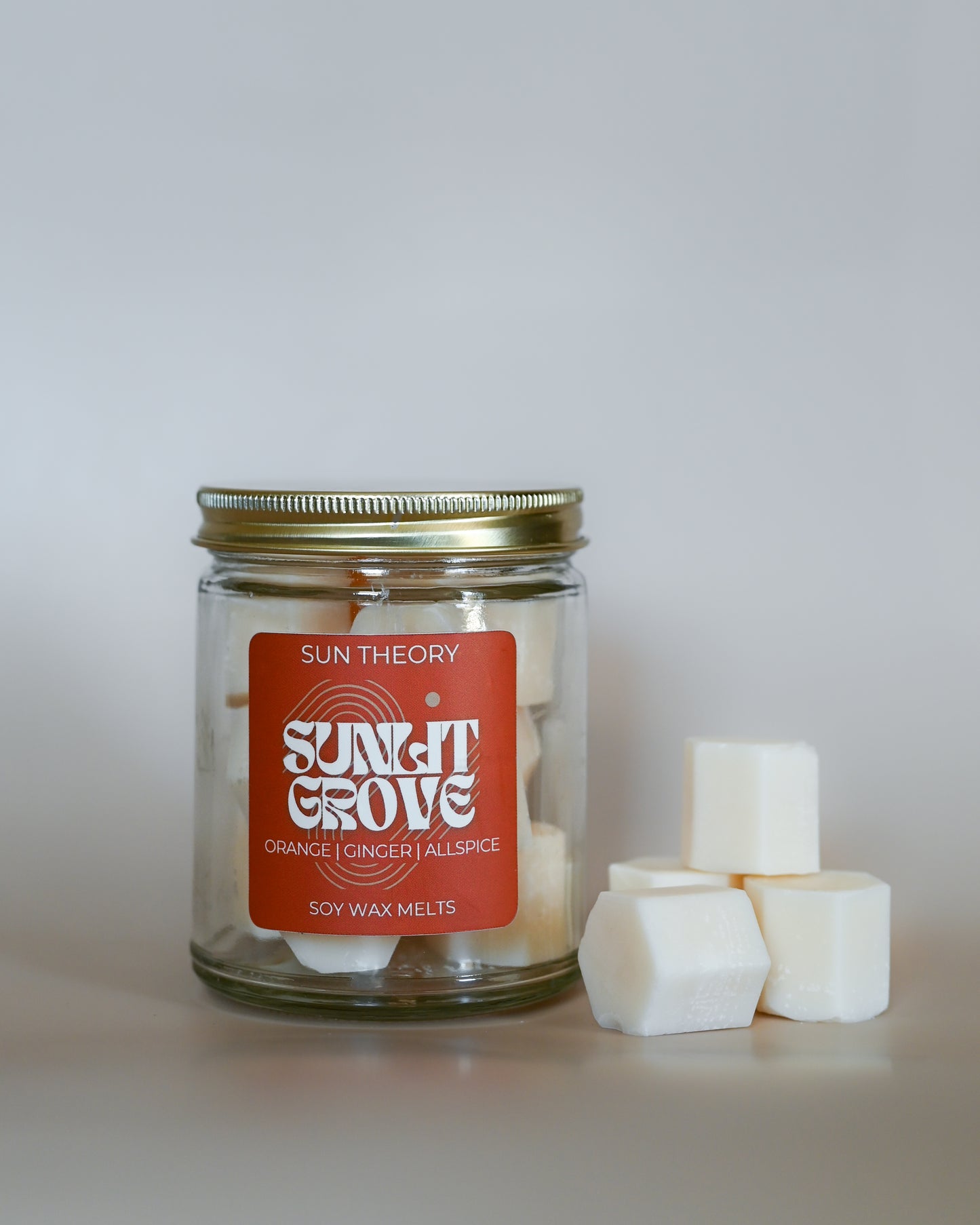 Jar of Sun Theory Sunlit Grove Soy Wax Melts with a red label on a white background