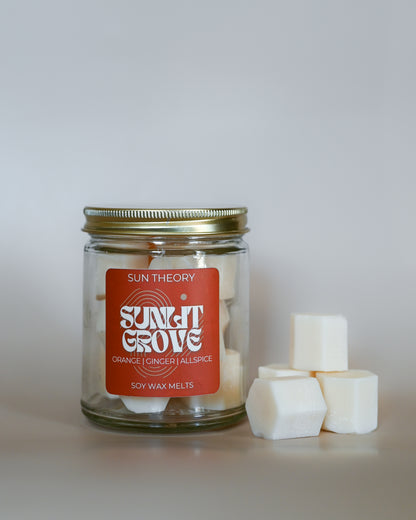 Jar of Sun Theory Sunlit Grove Soy Wax Melts with a red label on a white background