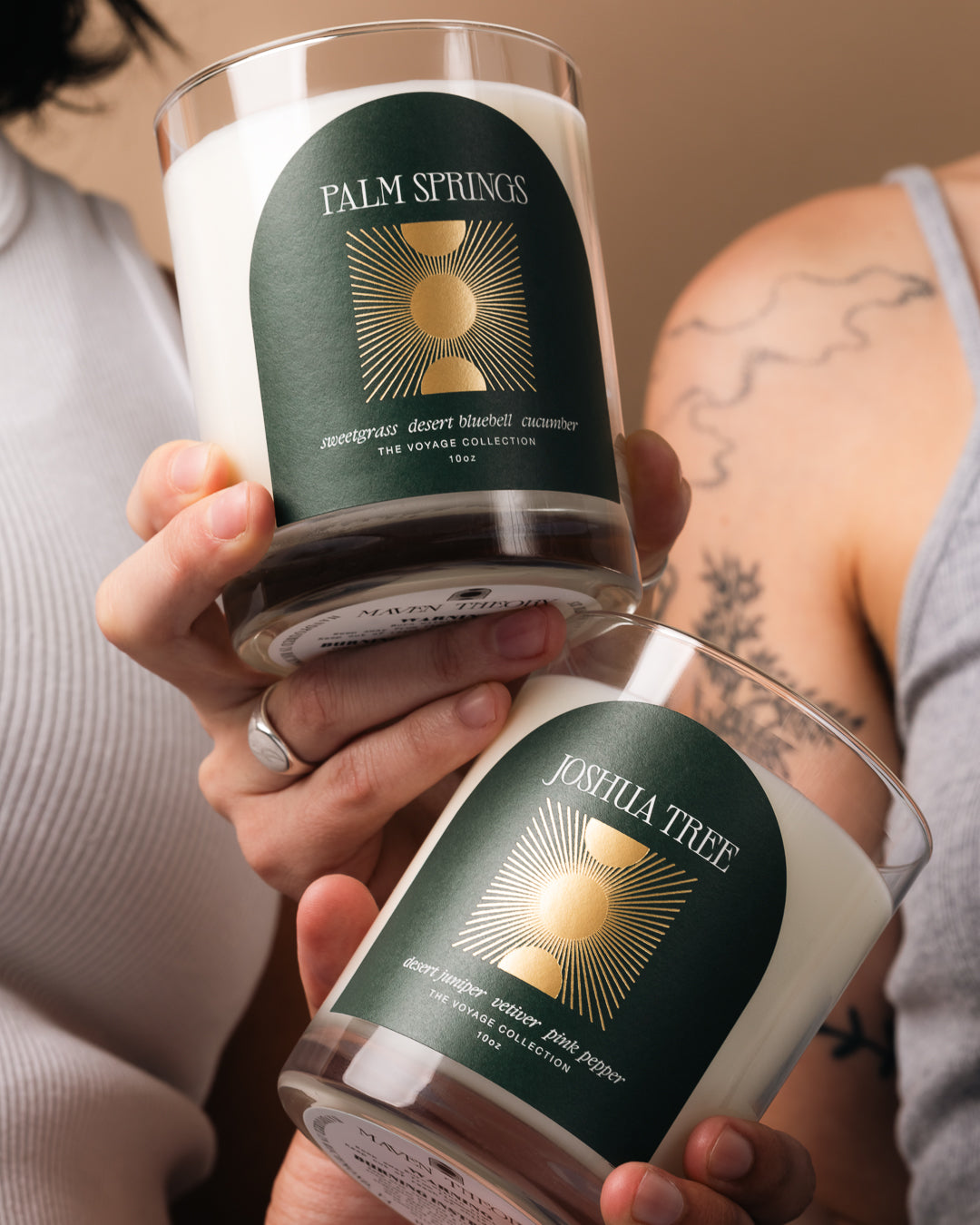 Two candles with 'Palm Springs' and 'Joshua Tree' labels held by a person.