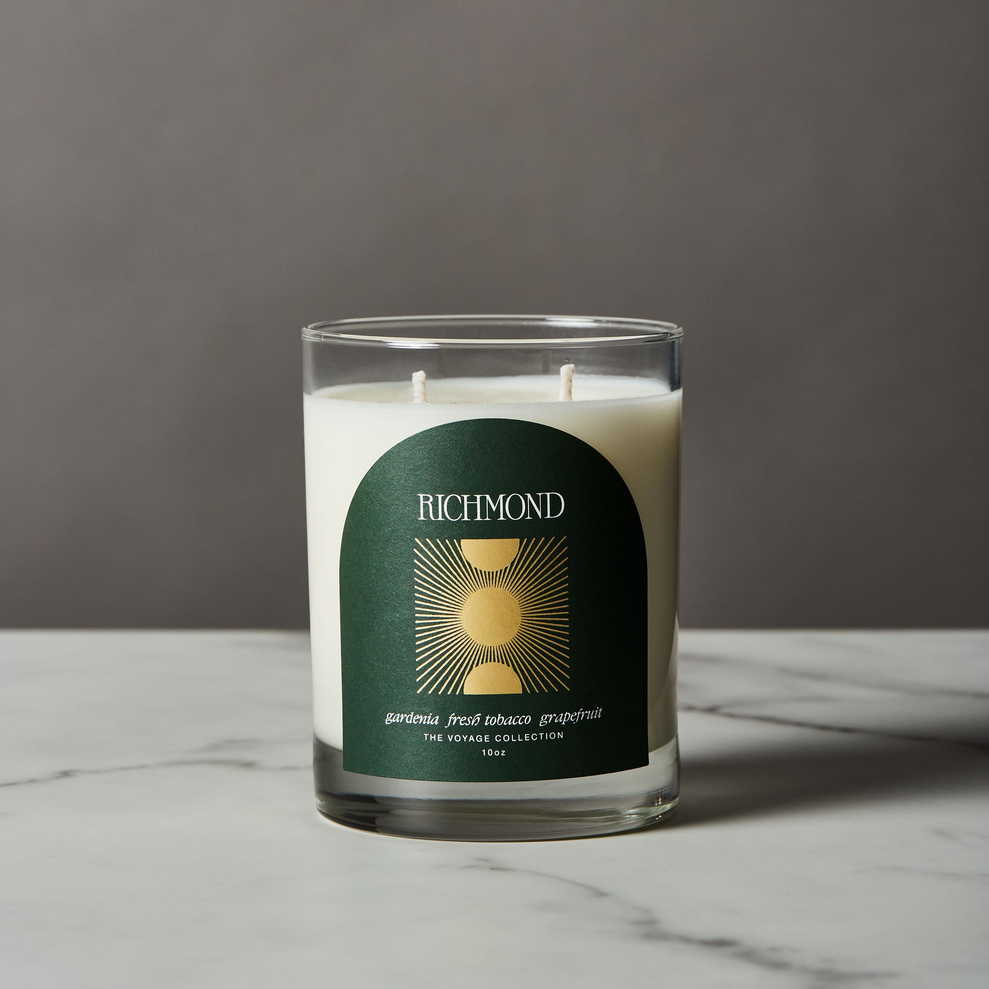 Candle with a green label on a marble surface and gray background
