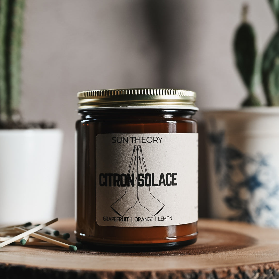 Candle in an amber colored jar labeled "citron solace"