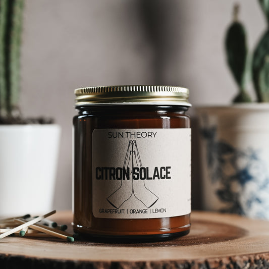Candle in an amber colored jar labeled "citron solace"