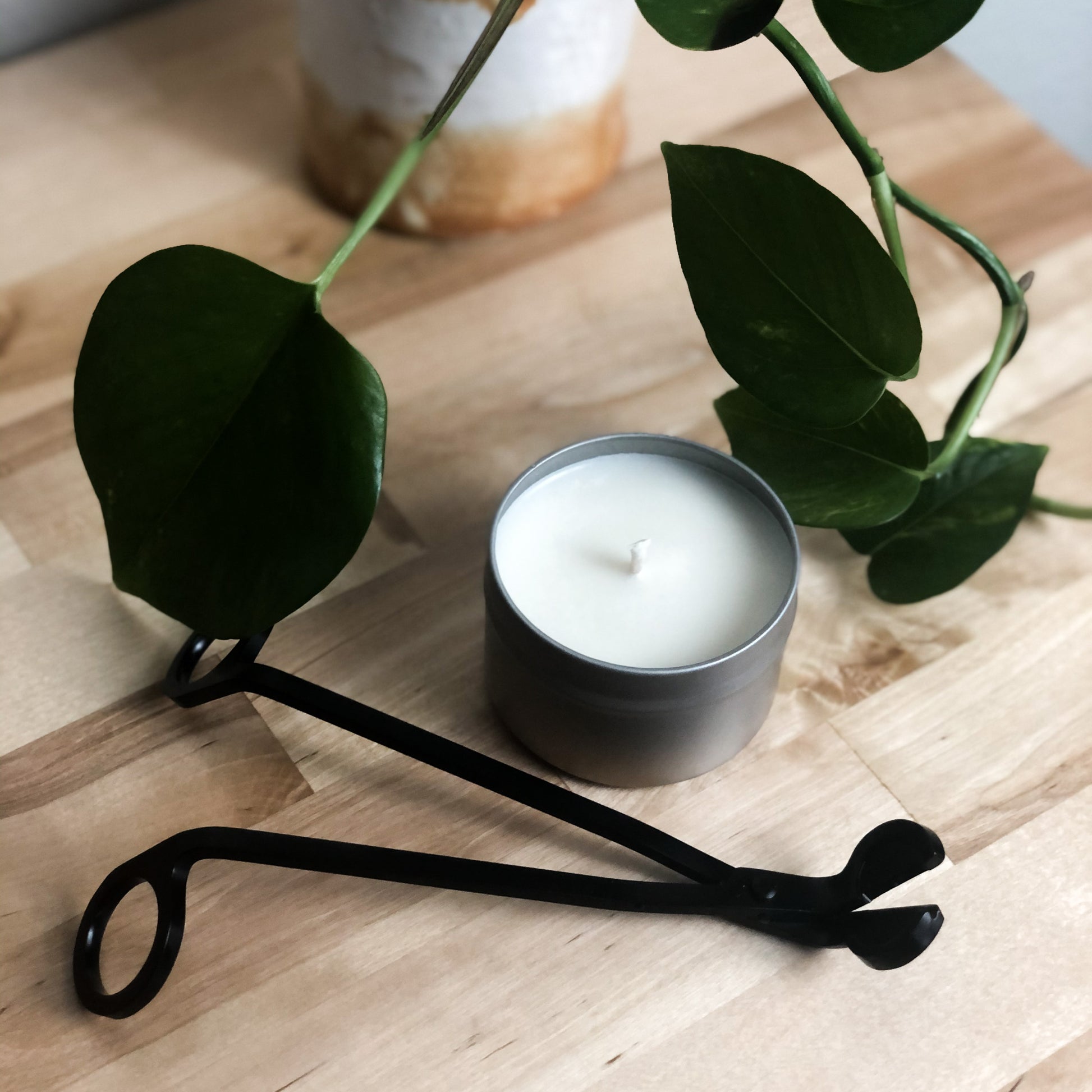 Matte Black Wick Trimmer on table next to candle