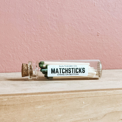 Glass jar of matchsticks laying on its side