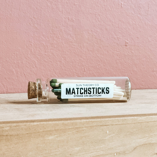 Glass jar of matchsticks laying on its side